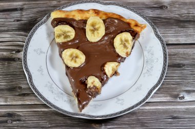 Fındık kremalı ve fırında pişirilmiş taze muz meyveli çikolata ezmeli, çikolatalı ve muzlu pizza hamurlu, atıştırmalık olarak tatlı dilimleri
