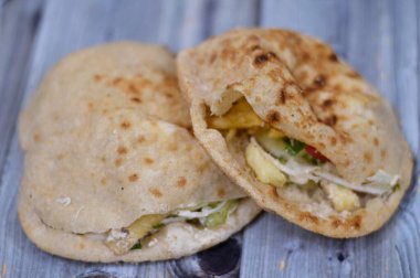 Flat bread filled with french fries and green salad, traditional Egyptian fried potatoes fingers sandwich surrounded by cool and crunchy diced tomatoes, cucumbers, onions, lettuce, red cabbage slices