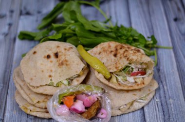 Patates kızartması, sandviç, fasulye püresi ve patlıcan, biber ve havuç turşusu ile doldurulmuş geleneksel Mısır falafel sandviçi.