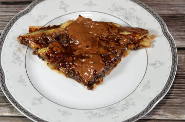 Çikolata fırınlanmış tatlı ve kurabiyelerle doldurulmuş, kahverengi çikolata ezmesi ve sosla kaplanmış, Feteer meshaltet yastıklı kek ve çikolatayla doldurulmuş pasta.