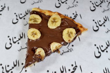 Kahire, Mısır, 13 Kasım 2024: Fındık kremalı ve fırında pişirilmiş taze muz meyveli çikolata ezmeli tatlı pizza Lübnan fırınından fırınlanmış pizza tatlısı