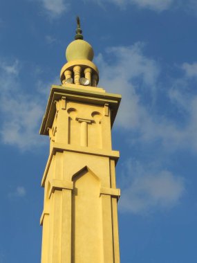 Mavi bulutlu gökyüzü, minare veya kuleye karşı ahşap süslemeli yüksek minare, İslam dini ve mimari konsepti, cami direği, seçici odak noktası