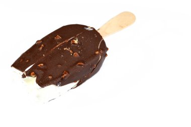 Vanilyalı dondurma çubuğu kaplanmış ve kahverengi çikolata katmanlı fındıklı, çikolata aromalı dondurmalı ve kızarmış fındıklı, seçici odaklı.