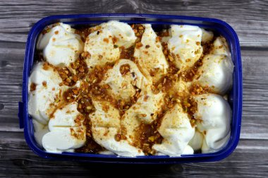 Karamel soslu Mistika Mastic Pistachio dondurması, tepesinde şam fıstığı parçaları olan karamelize makarna, yaz ve tatil konsepti, seçici odaklanma.