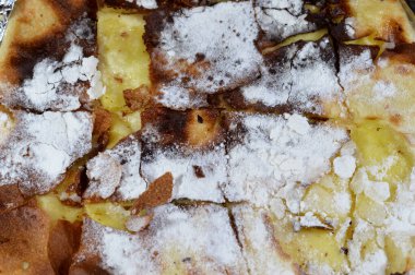 Yastıklı turtalara pudra şekeri ya da turta lapası gibi Feteer Meshaltet yastığı ince hamur katmanları ve vanilyalı muhallebi ile doldurulmuş ghee.