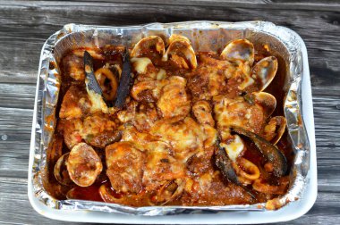 Karışık balık filetosu, karides, kalamar, mürekkep balığı yumurtası, balık yumurtası, balık yumurtası, midye, istiridye ve yengeçten oluşan fırında pişirilmiş çeşitli deniz ürünleri mutfağı, sıcak ve taze deniz ürünleri.