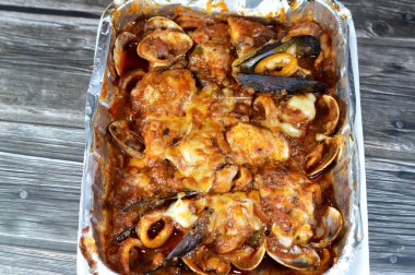 Karışık balık filetosu, karides, kalamar, mürekkep balığı yumurtası, balık yumurtası, balık yumurtası, midye, istiridye ve yengeçten oluşan fırında pişirilmiş çeşitli deniz ürünleri mutfağı, sıcak ve taze deniz ürünleri.