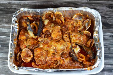 Karışık balık filetosu, karides, kalamar, mürekkep balığı yumurtası, balık yumurtası, balık yumurtası, midye, istiridye ve yengeçten oluşan fırında pişirilmiş çeşitli deniz ürünleri mutfağı, sıcak ve taze deniz ürünleri.