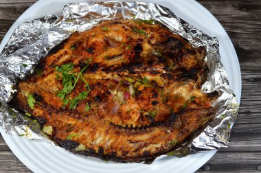 Sinjari Tilapia Balığı, balık yağ ve limonla açılır ve ızgara yapılır veya maydanozlu, domatesli, soğanlı ve küçük karidesli fırında pişirilir ve genellikle kırmızı balıklı pilavla servis edilir.