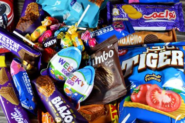 Kahire, Mısır, 29 Kasım 2024: Çeşitli çikolatalar, bisküviler, kekler, abur cuburlar ve patates cipsleri, Bimbo, Blazo, haftalık yumurta, kaplan patatesi, Freska çikolataları, Nawaem bisküvileri, bugün bar ve şeker karışımı