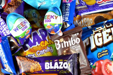 Kahire, Mısır, 29 Kasım 2024: Çeşitli çikolatalar, bisküviler, kekler, abur cuburlar ve patates cipsleri, Bimbo, Blazo, haftalık yumurta, kaplan patatesi, Freska çikolataları, Nawaem bisküvileri, bugün bar ve şeker karışımı