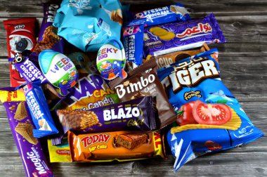 Kahire, Mısır, 29 Kasım 2024: Çeşitli çikolatalar, bisküviler, kekler, abur cuburlar ve patates cipsleri, Bimbo, Blazo, haftalık yumurta, kaplan patatesi, Freska çikolataları, Nawaem bisküvileri, bugün bar ve şeker karışımı