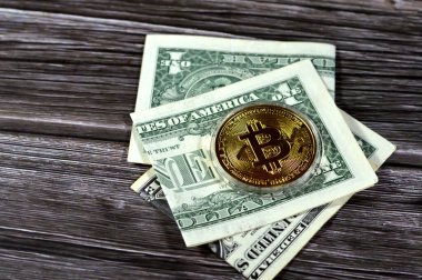 Bitcoin fiziksel altın sikke ile Amerikan dolar banknotu, BTC 1. Merkezi olmayan kripto para birimi, P2P bitcoin ağındaki düğümler işlemleri kriptografi ile doğruladı ve blockchain ile kaydedildi