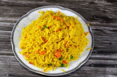 Uzun tahıllı sarı Basmati pilavı sebzeli, havuçlu ve bezelyeli geleneksel Çin buğulamalı pilav genellikle soya soslu tavuk, tatlı ve ekşi veya kırmızı biberli geleneksel Çin yemeği ile servis edilir.