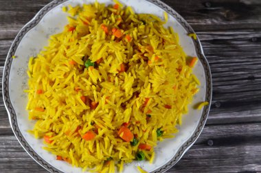 Uzun tahıllı sarı Basmati pilavı sebzeli, havuçlu ve bezelyeli geleneksel Çin buğulamalı pilav genellikle soya soslu tavuk, tatlı ve ekşi veya kırmızı biberli geleneksel Çin yemeği ile servis edilir.