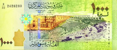 Suriye 2013 merkez bankası tarafından yayınlanan Bin Suriye pound banknotunun ters tarafının büyük bir kısmında Bosra amfitiyatrosu, Suriye parası ve ekonomi konsepti, seçici odak noktası yer alıyor.