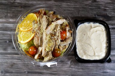 Tavuk Sezar salatası, limon suyu, zeytin yağı, Dijon hardalı, parmesan peyniri, kiraz domatesleri, tavuk göğsü ve portakal dilimleriyle süslenmiş yeşil marul ve kızarmış ekmek salatası.