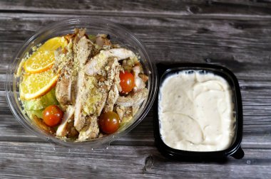 Tavuk Sezar salatası, limon suyu, zeytin yağı, Dijon hardalı, parmesan peyniri, kiraz domatesleri, tavuk göğsü ve portakal dilimleriyle süslenmiş yeşil marul ve kızarmış ekmek salatası.