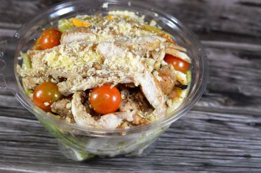 Tavuk Sezar salatası, limon suyu, zeytin yağı, Dijon hardalı, parmesan peyniri, kiraz domatesleri, tavuk göğsü ve portakal dilimleriyle süslenmiş yeşil marul ve kızarmış ekmek salatası.
