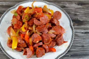 Sosis (Viyana sosisi) adı verilen ızgara sosisli sandviçi dilimler ve soğan dilimleri ve renkli dolma biberlerle sosis, sıcak suda kaynatıldıktan sonra yağla kızartılır.