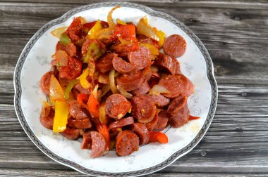 Sosis (Viyana sosisi) adı verilen ızgara sosisli sandviçi dilimler ve soğan dilimleri ve renkli dolma biberlerle sosis, sıcak suda kaynatıldıktan sonra yağla kızartılır.