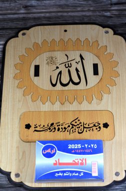 Kahire, Mısır, 11 Aralık 2024: Gregorian ve Hijri bloklarıyla günlük ahşap asma takvimi 2025 yılı Arapça dilinde, üzerinde Allah 'ın adı Arapça yazılmış.
