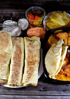 Makine ızgara tavuk ızgara, Suriye tarifi ile yapılan tavuklar, sulu, sulu ve Suriye usulü tavuk shawerma veya shawarma tortilla paketleri, kızarmış patates cipsi, tomiya sarımsak sosu, Arap turşusu.