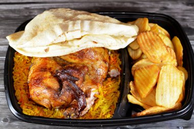 Arap mutfağından ızgara ızgara tavuk rengarenk Basmati pilavı ve kızarmış ince patates genellikle sarımsak sosu ve turşuyla servis edilen tek kullanımlık siyah tabakta servis edilir.