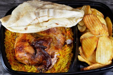 Arap mutfağından ızgara ızgara tavuk rengarenk Basmati pilavı ve kızarmış ince patates genellikle sarımsak sosu ve turşuyla servis edilen tek kullanımlık siyah tabakta servis edilir.