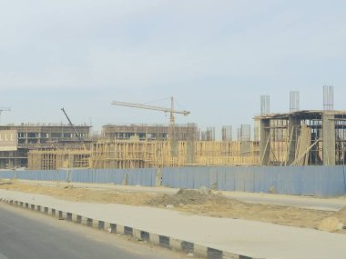 Cairo, Egypt, January 4 2025: A new high rise of residential apartments in new Cairo, New buildings under construction, Egyptian real estate projects, scaffoldings and cranes on a construction site clipart