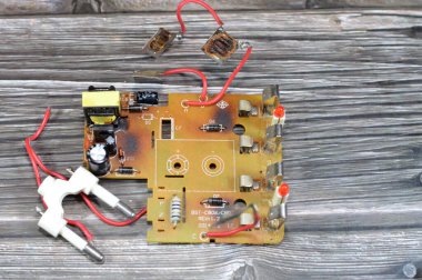 Kahire, Mısır, 7 Ocak 2025: Elektrik yüksek voltajı aşırı yüklenmesi veya yangın tehlikesi yaratan kısa devre, yanmış şarj edilebilir AA batarya şarj devresi