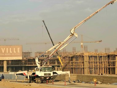 Cairo, Egypt, January 5 2025: New buildings and high rise of residential apartments in new Cairo, truck-mounted concrete boom pump pouring concrete to new building, Egyptian real estate new project clipart