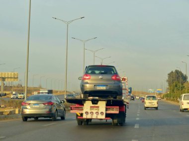 Kahire, Mısır, 19 Ocak 2025: Bir çekici kurtarma taşıyıcısı hidrolik kamyon bozuk bir arabayı yolda hareket ettiriyor, bakım için sokaktan bir arabayı kurtarıyor, seçici odak noktası