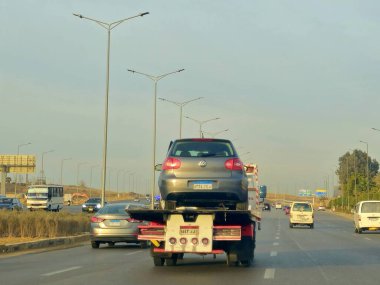 Kahire, Mısır, 19 Ocak 2025: Bir çekici kurtarma taşıyıcısı hidrolik kamyon bozuk bir arabayı yolda hareket ettiriyor, bakım için sokaktan bir arabayı kurtarıyor, seçici odak noktası