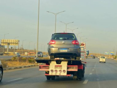 Kahire, Mısır, 19 Ocak 2025: Bir çekici kurtarma taşıyıcısı hidrolik kamyon bozuk bir arabayı yolda hareket ettiriyor, bakım için sokaktan bir arabayı kurtarıyor, seçici odak noktası