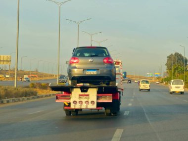 Kahire, Mısır, 19 Ocak 2025: Bir çekici kurtarma taşıyıcısı hidrolik kamyon bozuk bir arabayı yolda hareket ettiriyor, bakım için sokaktan bir arabayı kurtarıyor, seçici odak noktası