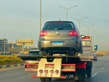 Kahire, Mısır, 19 Ocak 2025: Bir çekici kurtarma taşıyıcısı hidrolik kamyon bozuk bir arabayı yolda hareket ettiriyor, bakım için sokaktan bir arabayı kurtarıyor, seçici odak noktası