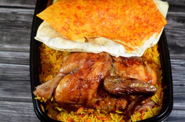 Arap mutfağından ızgara ızgara tavuk rengarenk Basmati pilavı ve kızarmış ince patates genellikle sarımsak sosu ve turşuyla servis edilen tek kullanımlık siyah tabakta servis edilir.