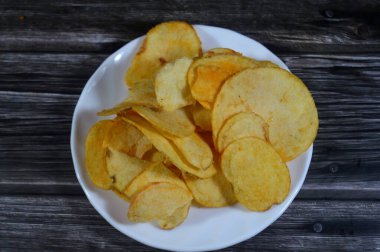 Patates cipsi, cips, ince patates dilimleri, kızartılmış, pişirilmiş, veya kızarana kadar havada kızartılmış, aperatif, meze veya meze olarak servis edilmiş, temel cips pişti ve tuzlandı, bazıları diğer tatlarla birlikte.