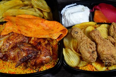 Renkli Basmati pilavlı ızgara tavuk ve kızarmış ince patates ve renkli Basmati pirinçli Broasted tavuk yemeği, salatalık dilimleri, salatalık turşusu.