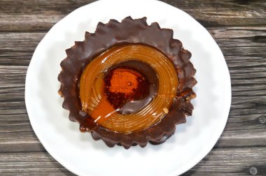 Çikolata ve karamelli tart, bisküvi tabanlı, karamel ve çikolatayla dolu bir hamur hamuru, içecek ya da ikram, seçici bir odak noktası,