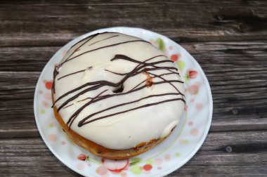 Kahverengi çikolata soslu beyaz çikolatalı çörek, jöleli, mayalı, Amerikan usulü yüzük donutu, mayalanmış hamur tatlısı, seçici bir odak noktası.