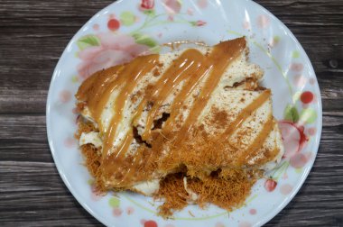 Mısır tatlısı bazbousa irmikli pasta, kunafa knafeh, krem şanti, karamel sosu birlikte tatlandırılmış ve üzeri tarçın ve karamel, Ramazan tatlıları ve şekerlerle kaplı.