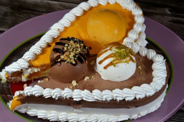 Dondurma ve çeşitli aromalı dondurmalar. Dondurma ve krema içinde kek katmanı olan çeşitli tatlar. Üzerinde karamel sosu olan mango, vanilya ve çikolata.