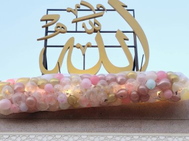 Arapça metnin tercümesi (Allah, Allah), Kahire 'de bir camide, minarenin yanında onlarca balon bulunan bayram kutlamaları, Kurban Bayramı' nda çocuklara atılacak.