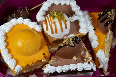 Dondurma ve çeşitli aromalı dondurmalar. Dondurma ve krema içinde kek katmanı olan çeşitli tatlar. Üzerinde karamel sosu olan mango, vanilya ve çikolata.