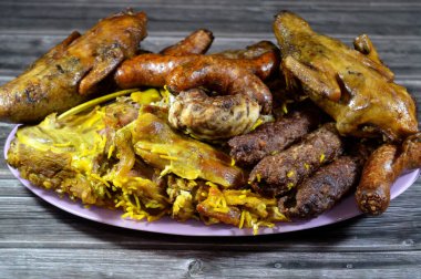 Doldurulmuş güvercin ya da Mısırlı Hamam Mahshi, biftek Kufta, kofta şiş kıyma, mangalda ızgara tavuk, iyi pişmiş kuzu eti ve kaburga, doldurulmuş mumya sosisi karışımı.