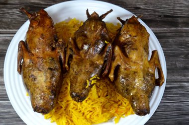 Beyaz pirinçle doldurulmuş kızarmış güvercinler ya da Hamam mahshi, pişene kadar haşlanmış, sonra kızartılmış, sıcak yağda kızartılmış, ya da ızgarada kızartılmış, Sarı Basmati uzun tahıllı Hint pirinci, Mısır güvercin mutfağı