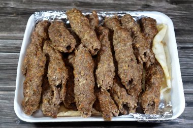 Arabic cuisine traditional food beef  Kofta, kebab and tarb kofta which is minced meat wrapped in lamb fat charcoal grilled and served on flatbread, oriental grilled barbecued meat food