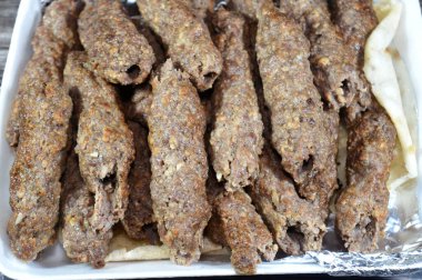 Arabic cuisine traditional food beef  Kofta, kebab and tarb kofta which is minced meat wrapped in lamb fat charcoal grilled and served on flatbread, oriental grilled barbecued meat food